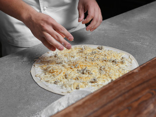 Cook preparing pizza