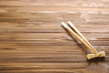 Light chopsticks on wooden background
