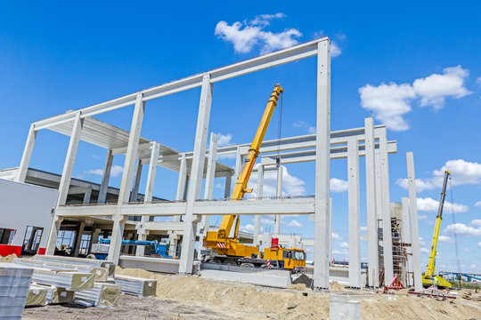 Mobile crane is unloading concrete joist from truck trailer