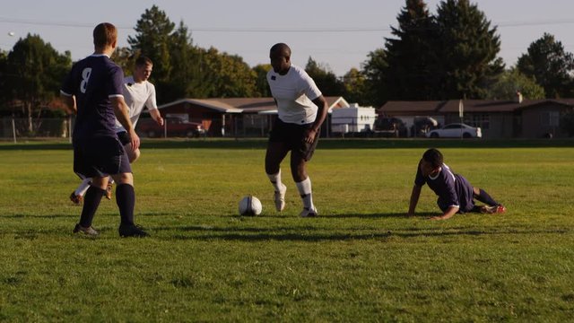 High school boys playing soccer in the park - 4K