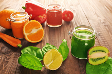 Tasty smoothie drinks with vegetables and fruits on table