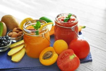 Tasty smoothie drinks with vegetables and fruits on table
