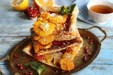 Tray with citrus cake slices on wooden background
