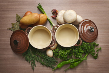 Ingredients for soup and bowls on wooden background