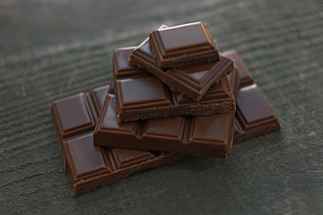Pile of milk chocolate bars on old wooden background