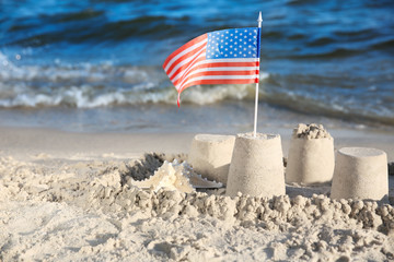 Sand castle with American flag on beach