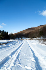 Obraz premium tire marks on the road with snow in the valley