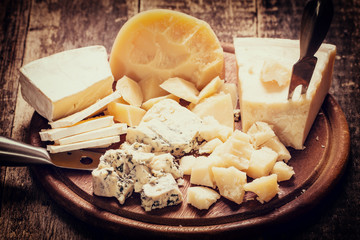 Composition of cheese, berries, bottles and glasses of wine on a wooden table