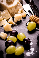 Composition of cheese, berries, bottles and glasses of wine on a wooden table