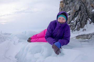 Fototapeta na wymiar Girl and transparent ice of Lake Baikal in the cold