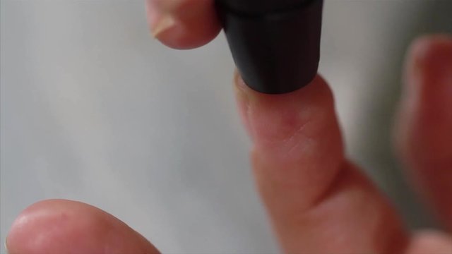 Macro video of self testing for diabetes blood sample is being taken by a stick HD