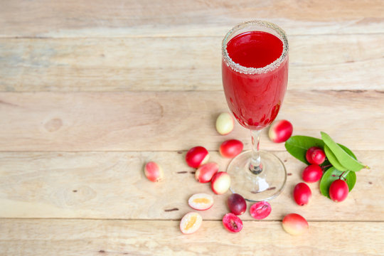 Carandas-plum  juice  in a glass on wooden background  
