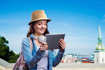 Fototapeta premium Tourist girl in denim shirt with tablet. Summer city.