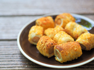 Bread sausage with cheese roll on the brown plate for enjoy tea break
