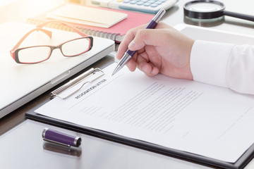 Fototapeta premium Businessman signing his resignation letter on his desk before sending to his boss to resign his job.