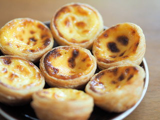 Delicious Asian Egg tart from the Hong Kong famous shop on the brown plate for healthy coffee break in the afternoon tea