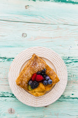 Delicious puff pastry with forest fruit on wooden table with space for text.