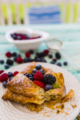 Delicious puff pastry with forest fruit on wooden table.