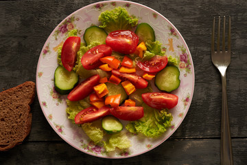 Vegetable salad and bread on a wooden table