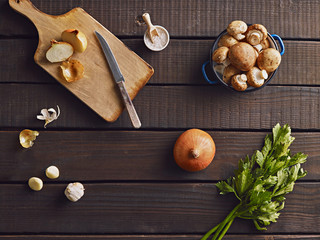 Fresh onion, garlic and mushrooms on the wooden background, prepared for cooking. Top view.