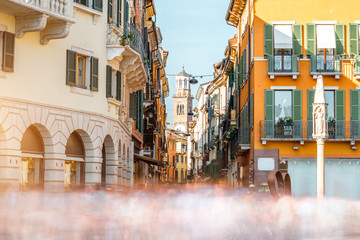 View on Giuseppe Mazzini famous commercial street with Lamberty tower in Verona city. Long exposure image technic with blurred people