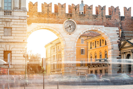 Portoni della Bra gate with clock in Verona city. Long exposure image technic with blurred cars and people