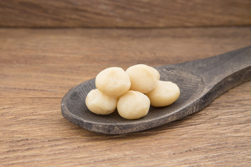 Macadamia nuts in wooden spoon.