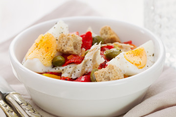 salad with fish and egg in white bowl