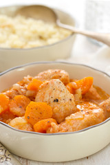 meat with carrot in bowl with fork and knife.
