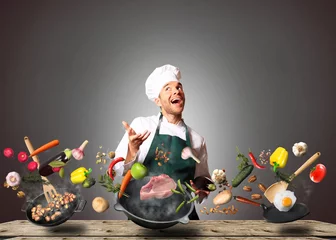 Foto auf Acrylglas Kochen Koch jongliert mit Gemüse und anderen Lebensmitteln in der Küche