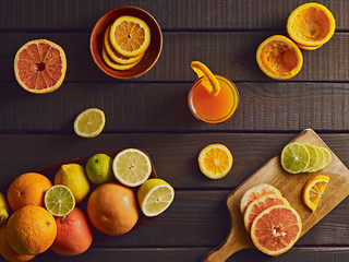 Preparing fresh citrus juice setting. Mixed citrus fruits on wooden table. Top view.