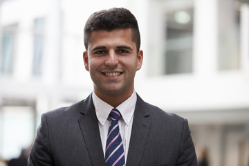 Head And Shoulders Portrait Of Young Businessman In Office