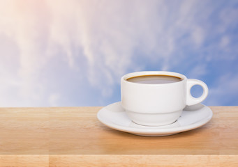 coffee cup on wood table on blue sky background