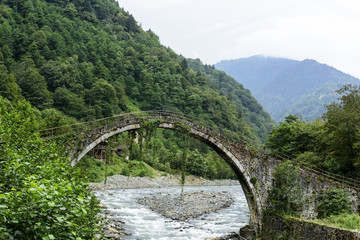 Fototapeta na wymiar beautiful old stone bridge on the river with long exposure shot