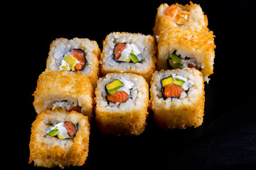 Japanese rolls with fish on a black background