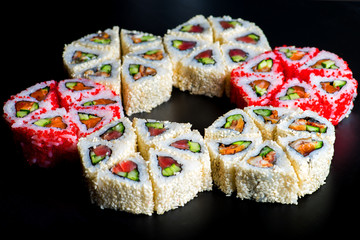 Japanese rolls with fish on a black background