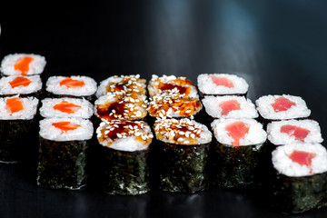 Japanese rolls with fish on a black background