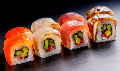 Japanese rolls with fish on a black background