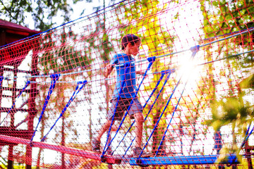 children's safety on playground. boy plays in the playground shielded with a protective safety net....