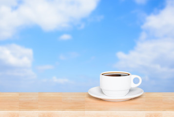 coffee cup on wood table on blue sky background