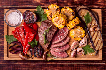 Grilled steak and vegetables on cutting board.