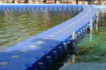 Many blue float buoy arrange in lake for walkway