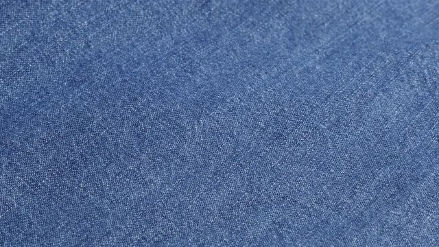 Dark blue high quality denim fabric details and texture close-up tilting 4K 2160p 30fps UltraHD video - Jeans dugaree cloth in blue color gathers slow tilt 4K 3840X2160 UHD footage 