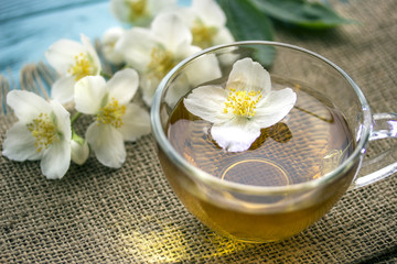 Fototapeta na wymiar jasmine tea and jasmine flowers on wooden background