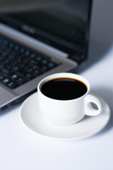 Laptop and coffee cup on white