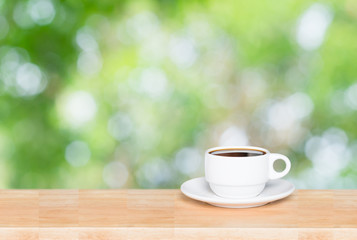 Coffee cup on the wooden table and green bokeh background