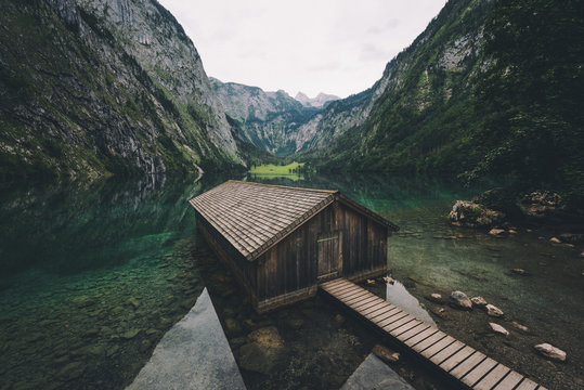 Wood cabin and mountains reflected in water 