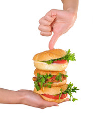 Beautiful female hands hold three burger. Closeup.