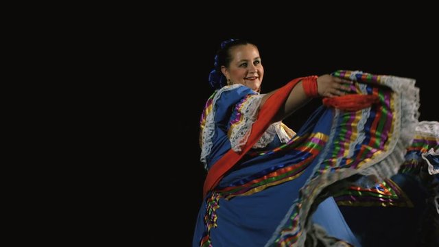 Slow motion shot of Mexican women in traditional dress dancing in the dark