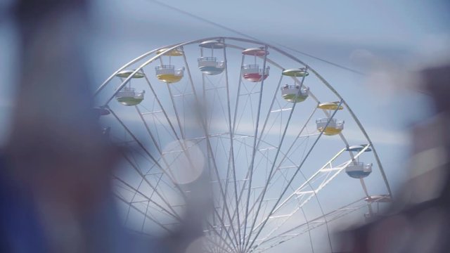 Observation wheel and cleer blue sky. Slow motion shot. 